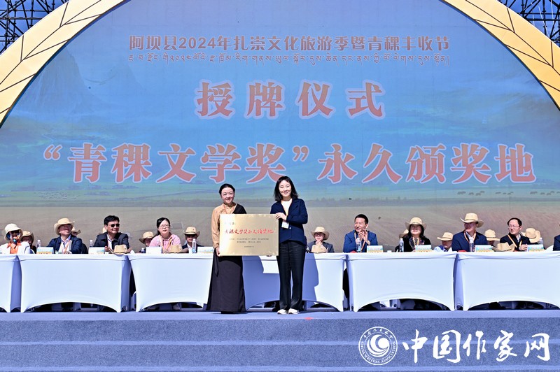 陳亞軍主編代表《民族文學(xué)》向阿壩縣授牌，紅梅部長(zhǎng)接牌。