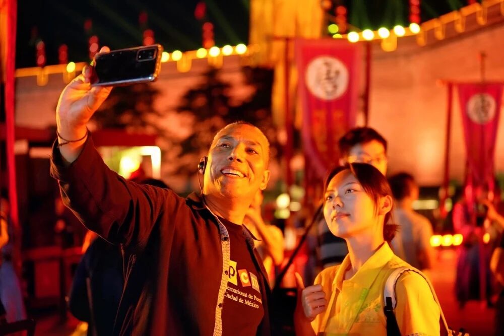 參加2025國際青春詩會的拉美詩人和中國詩人在西安永寧門觀看歡迎儀式。圖為墨西哥詩人馬努艾爾·夸烏特勒在歡迎儀式后與志愿者合影